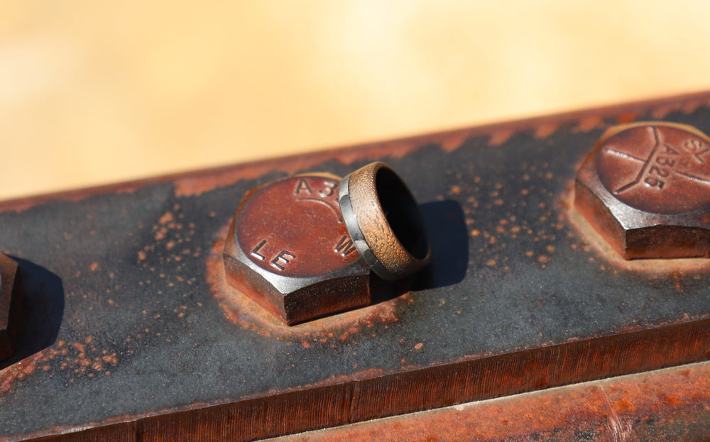 70/30 walnut wood ring with carbon fiber sleeve on a studded metal beam