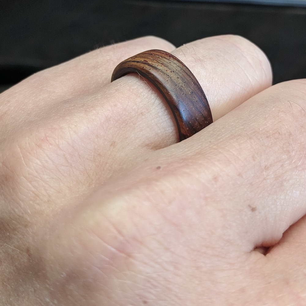 cocobolo ring with carbon fiber sleeve worn on finger