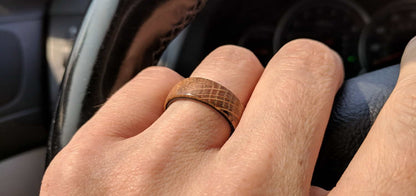 whiskey barrel ring with carbon fiber sleeve worn on a hand