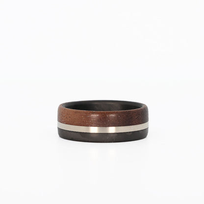 walnut wood and 14 karat white gold wedding ring with carbon fiber sleeve laying flat