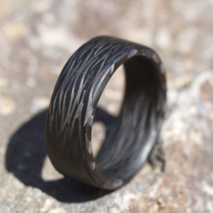 Men's Carbon Fiber Wedding Band on a sandstone rock